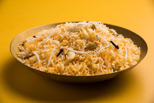 Ricetta di riso dolce al cocco noto anche come narali bhat a base di zafferano, anacardi, chiodi di garofano e servito in una ciotola bianca. Konkani popolare o cibo maharashtrian.