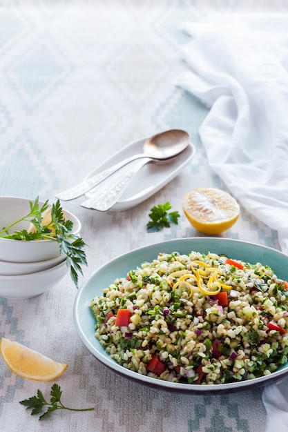 Ricetta mediorientale di verdure e grano tipo cous cous. Insalata vegetariana tradizionale mediorientale o araba con bulgur, prezzemolo, menta e pomodoro. Copia spazio