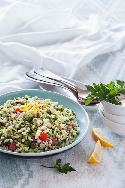 Ricetta mediorientale di verdure e grano tipo cous cous. Insalata vegetariana tradizionale mediorientale o araba con bulgur, prezzemolo, menta e pomodoro. Copia spazio