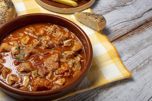 Ricetta tradizionale fatta in casa e tipica callos a la madrileÃ±a con pane e patatine fritte. Concetto di cibo spagnolo