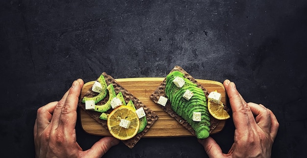 Ricette di cucina con avocado. Avocado verde maturo su un tagliere di legno per servire.