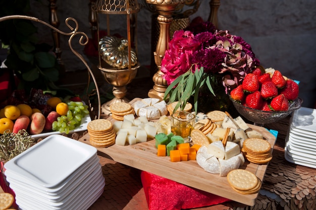 ricevimento con antipasti, caviale e crackers, formaggi e frutta decorati con fiori