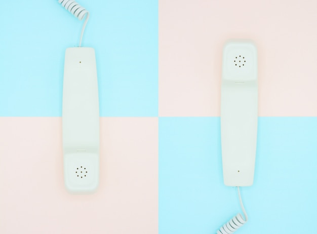 Ricevitore telefonico su sfondo blu e rosa