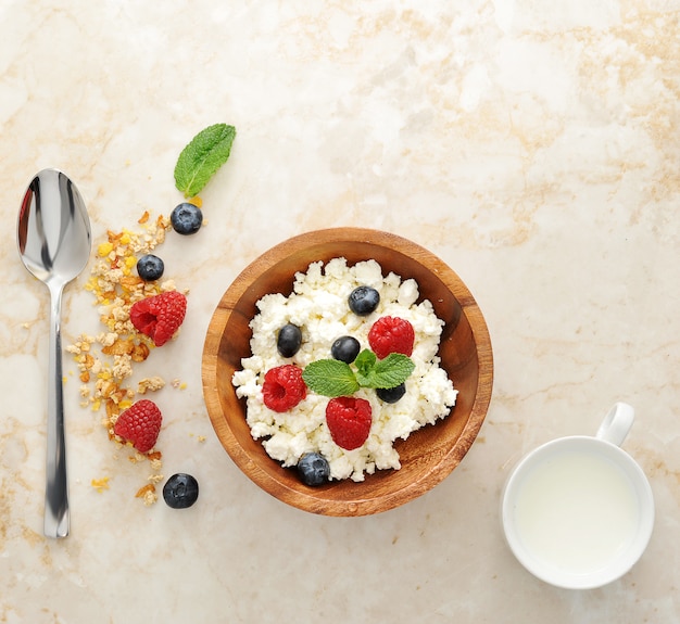 Ricotta con lamponi e mirtilli in una ciotola di legno