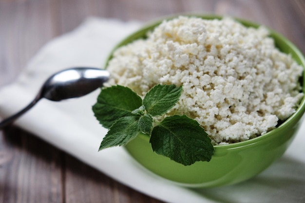 Ricotta con menta in una ciotola verde su un tovagliolo bianco Vista dall'alto