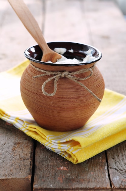 Ricotta cremosa in vaso di argilla sulla tavola di legno