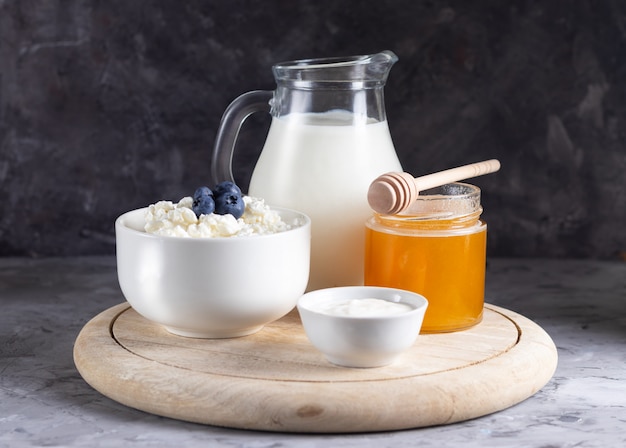 Ricotta di grano in una ciotola bianca con una brocca di latte su uno sfondo chiaro