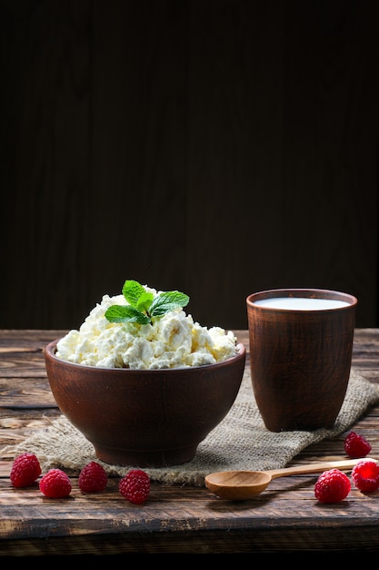 Ricotta e latte nell&#39;argilla sulla tavola di legno