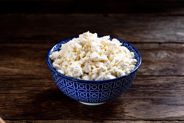 Ricotta fresca bianca in una ciotola blu sul tavolo della cucina.