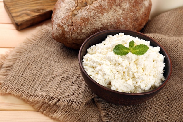 Ricotta in ciotola con pane sul tavolo da vicino