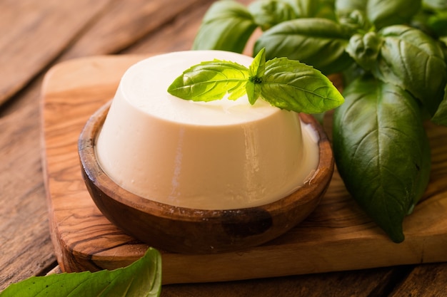 Ricotta in ciotola di legno rustica.