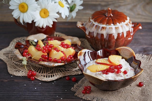 Ricotta, ribes rosso e pesche fresche su una superficie di legno