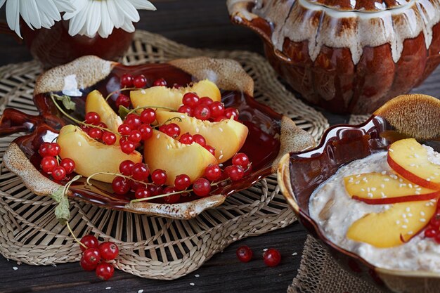 Ricotta, ribes rosso e pesche fresche su una superficie di legno