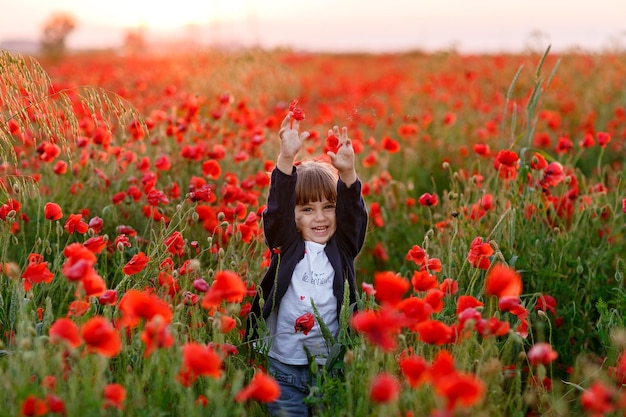 ride una bambina in un campo con i papaveri