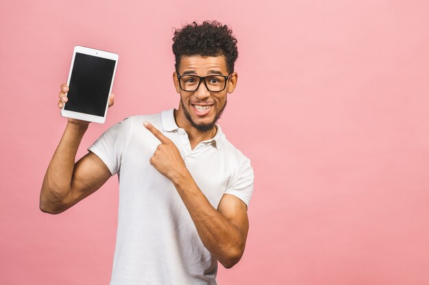 Ridendo giovane maschio afroamericano che tiene un tablet touch pad