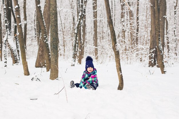 Ridere bambina sdraiata nella neve profonda.