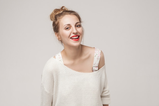 Ridere donna che guarda l'obbiettivo e sorriso a trentadue denti. Foto in studio, sfondo grigio