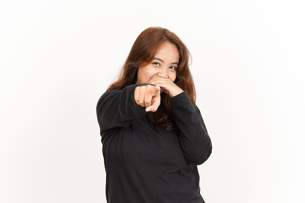 Ridere e indicare la fotocamera di una bella donna asiatica che indossa una camicia nera isolata on white