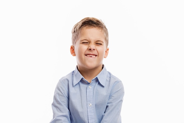 Ridere ragazzo di scuola in una camicia blu. Isolato su bianco