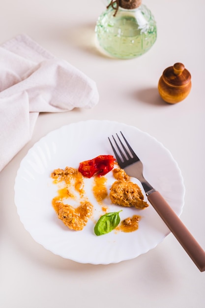 Rifiuti di cibo e posate su un piatto sporco sulla tavola vista verticale