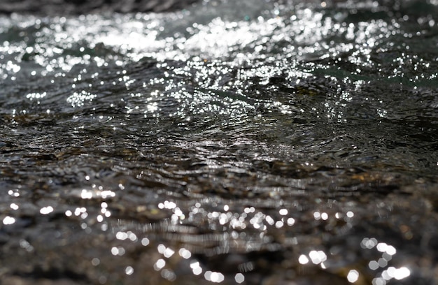 Riflessi di luce sulla superficie dell'acqua acqua in movimento Perfetta immagine di sfondo