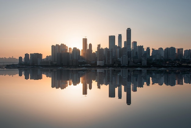 Riflessione degli edifici in mare contro il cielo durante il tramonto