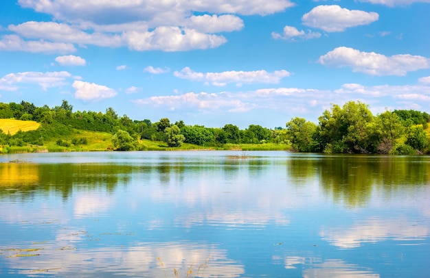 Riflessione del cielo nuvoloso blu nel fiume calmo