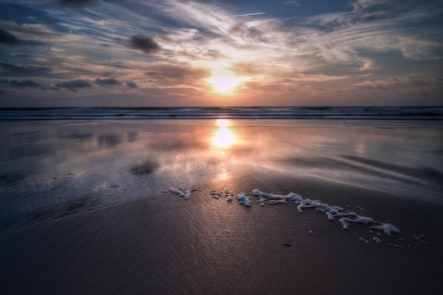 Riflessione del sole sulla spiaggia sabbiosa durante il tramonto