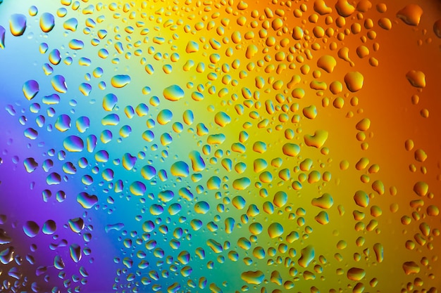 Riflessione dell'arcobaleno nelle gocce di pioggia sul vetro.