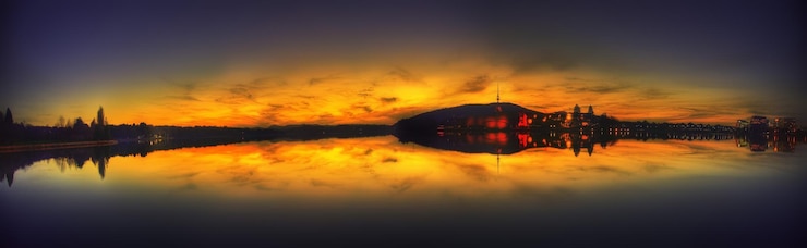 Foto riflessione delle silhouette degli edifici nel lago contro il cielo durante il tramonto