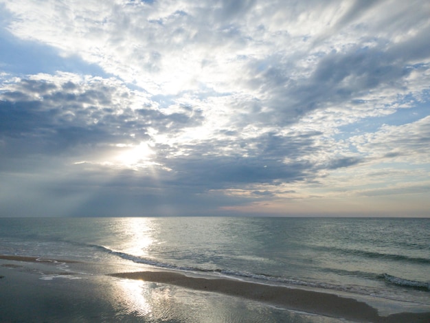 Riflessione di un cielo nuvoloso in mare all'alba mare