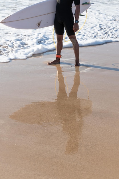 Riflessione di un surfista sulla spiaggia