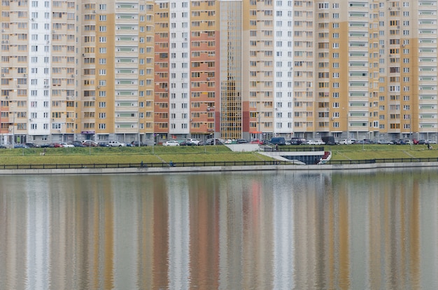 Riflessione ritmata di case multicolori del nuovo quartiere di Mosca nello stagno. bilanciamento del colore