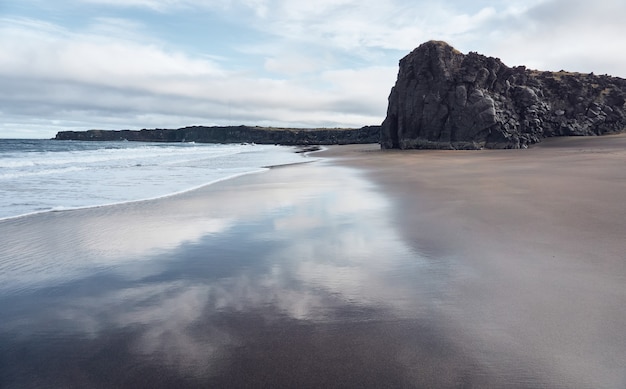 Riflesso del cielo nella sabbia della spiaggia bagnata dalle onde