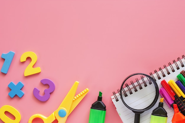 Rifornimenti di scuola su fondo rosa per istruzione e di nuovo al concetto della scuola