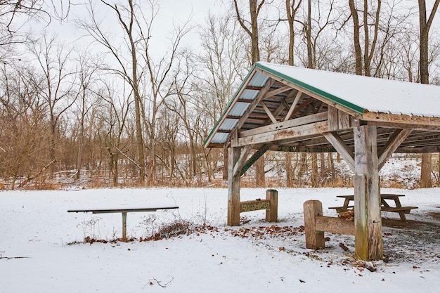 Rifugio per picnic coperto di neve nel parco invernale Scena tranquilla
