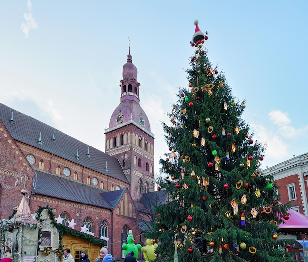 Riga, Lettonia - 25 dicembre 2015: Persone all'albero di Natale al mercatino di Natale nella piazza del Duomo, nel centro della vecchia Riga, Lettonia.