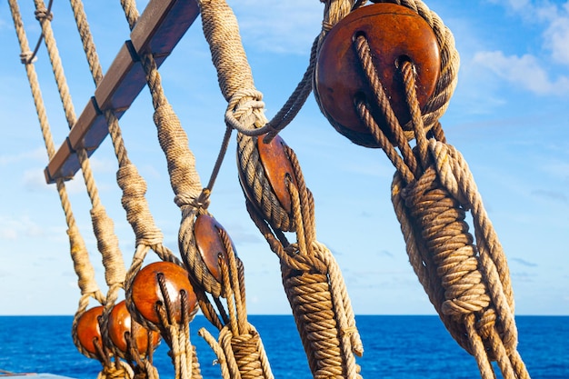 Rigging vecchia nave di legno sullo sfondo del mare e del cielo con pulegge e funi della scala di corda