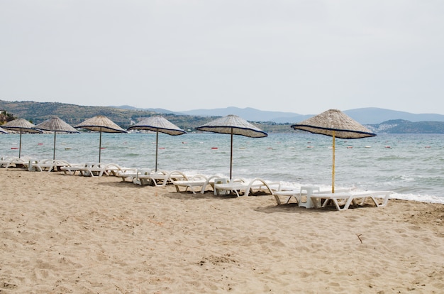 Righe di lettini vuoti e ombrelloni sulla spiaggia. Camel Beach in Turchia.