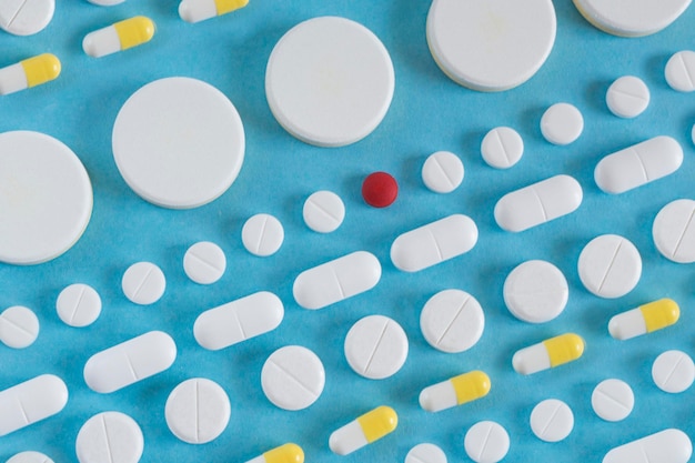 Righe di pillole bianche su sfondo blu concetto di medicina