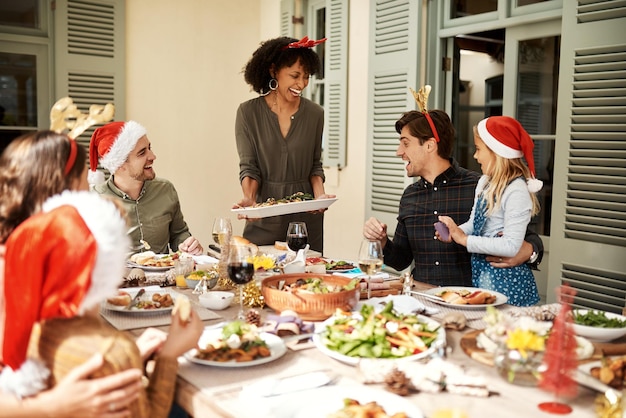 Riguarda il cibo e l'essere allegri Foto ritagliata di una famiglia felice che pranza insieme il pranzo di Natale