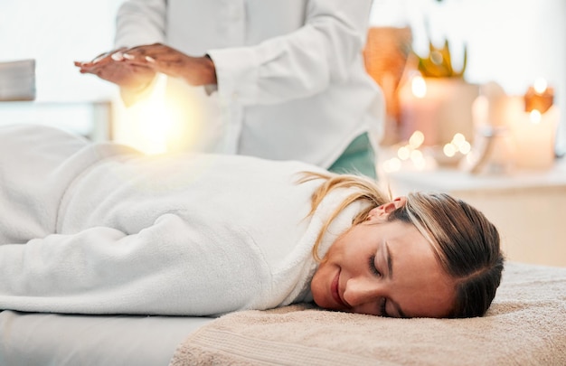 Rilassa il reiki e la donna a letto alla spa per la terapia dei chakra con energia luminosa e medicina olistica Equilibrio di guarigione spirituale e persona zen con mentalità pacifica e sana al massaggio tradizionale