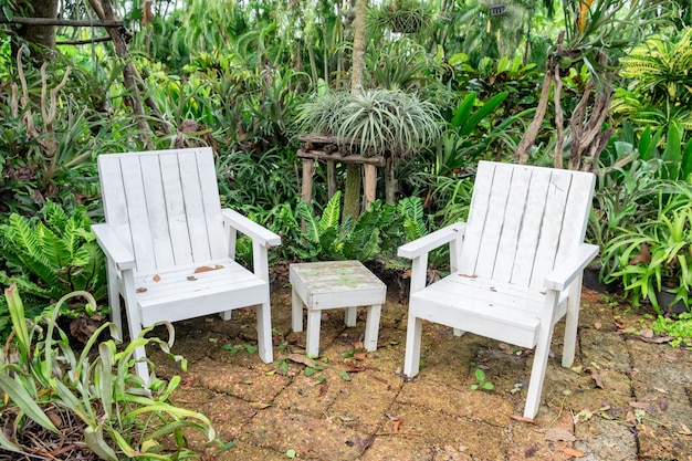 Rilassamento bianco della sedia e della tavola in giardino