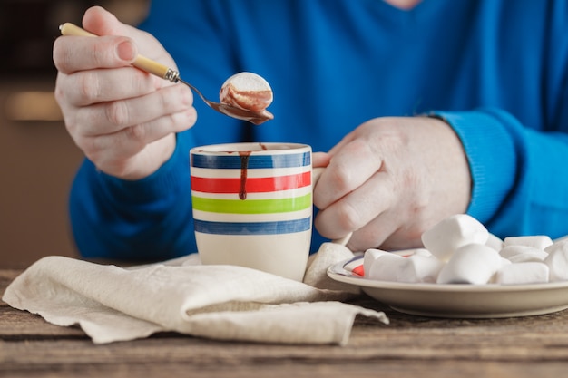 Rilassamento serale, tazza piena di cioccolata calda e marshmallow e caramelle