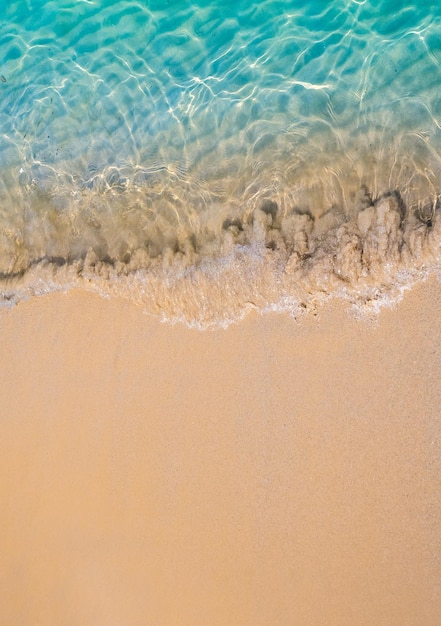 Rilassante scena della spiaggia vista dall'alto Movimento di acqua di mare blu e onda surf sulla spiaggia sabbiosa pulita oceano riva del mare costa vacanze estive vacanza sfondo con copia spazio stile verticale