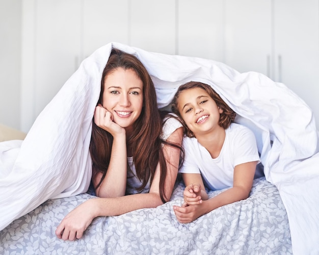 Rilassarsi nella nostra fortezza coperta Ritratto di una madre e una figlia che si rilassano insieme a casa al mattino