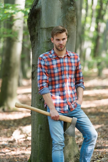 Rilassati dopo il lavoro. trascorrere un weekend di picnic nella foresta. uomo pronto per spaccare la legna e tagliare la legna da ardere con l'ascia. prepararsi ad abbattere albero. spaccare e spaccare la legna con l'ascia. falegname in legno.
