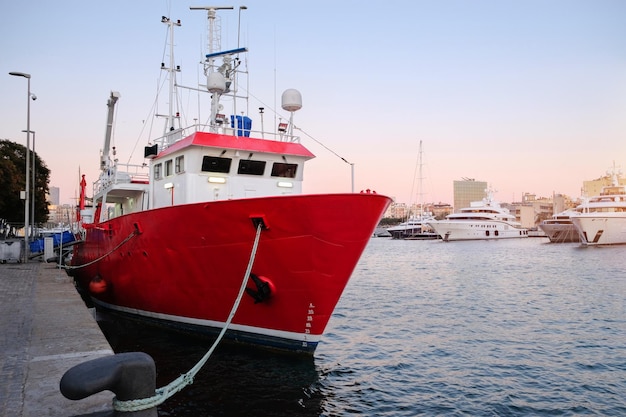 Rimorchiatore al porto marittimo del carico del molo del porto Barche e gru