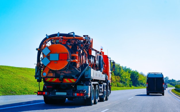 Rimorchio per autocarri con liquami e rifiuti sottovuoto in strada. Veicolo auto per servizi di utilità settica su strada carrabile. Trasporto europeo con cisterna per liquidi al trasporto. Trasportare in autostrada.