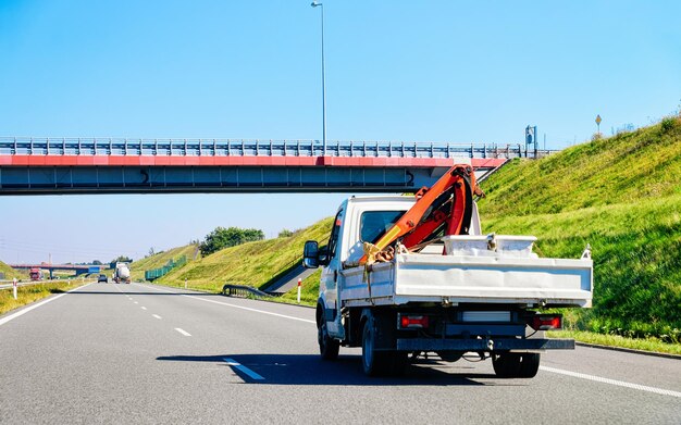 Rimorchio per il trasporto di camion con gru sulla strada asfaltata in Slovenia.